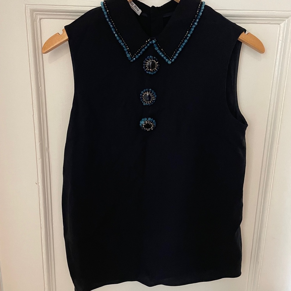 Miu Miu sleeveless black silk top with menswear-inspired beaded embellishments.